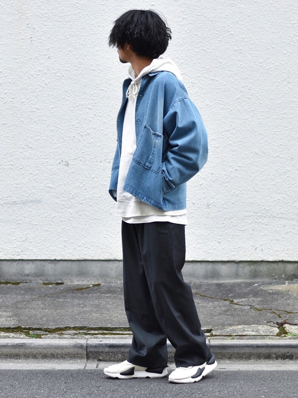 ブルー系のデニムジャケット、ホワイト系のパーカー、グレー系のスラックスを着用したメンズの春コーディネートの1枚目の写真