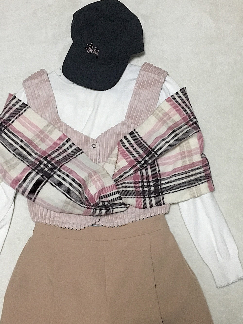 ピンク系のベスト、ベージュ系のチノパンツ、ピンク系のマフラーを着用したレディースの冬コーディネートの1枚目の写真