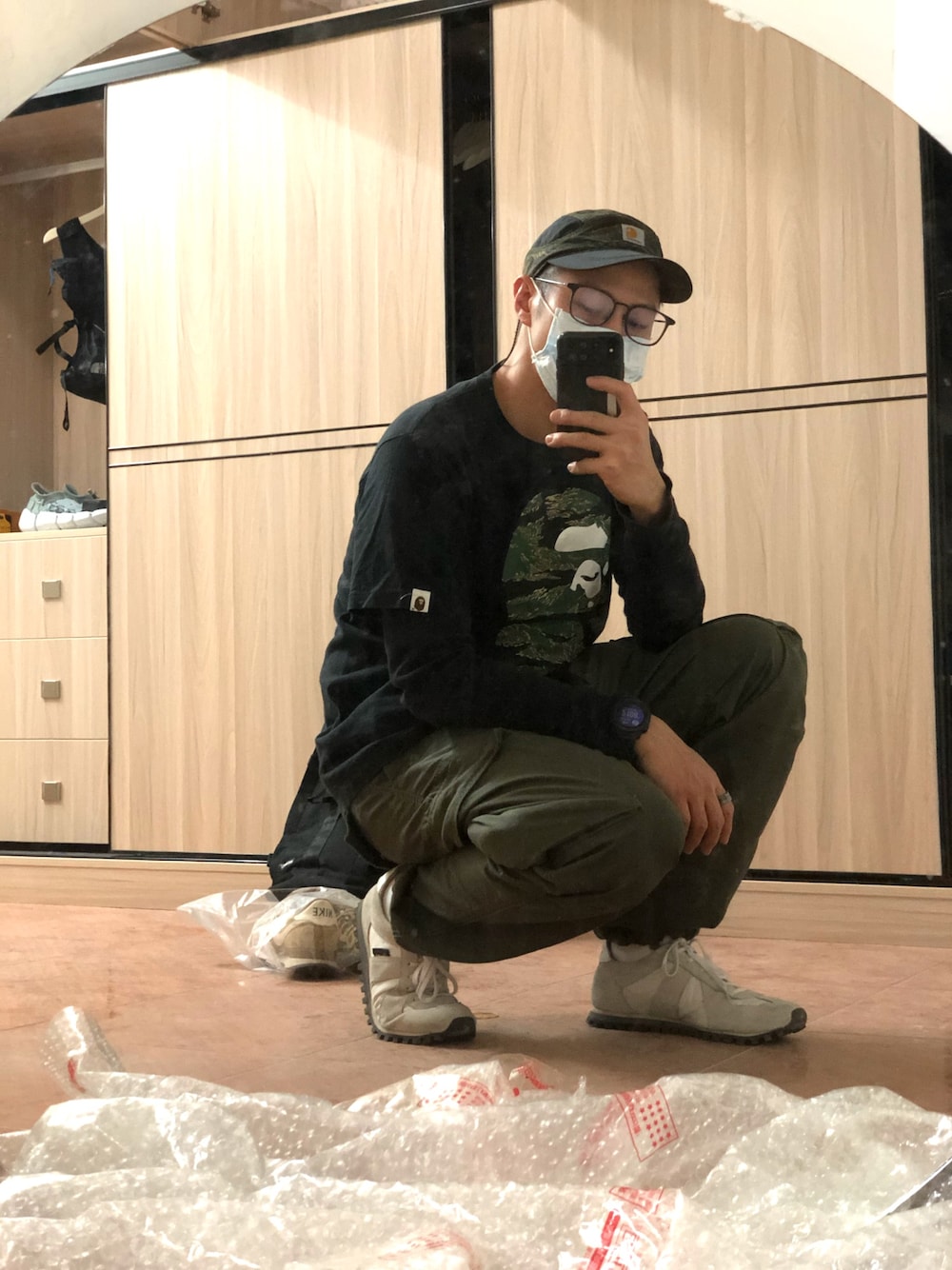 ブラック系のTシャツ/カットソー、グリーン系のカーゴパンツ、グレー系のスニーカーを着用したメンズの冬コーディネートの1枚目の写真