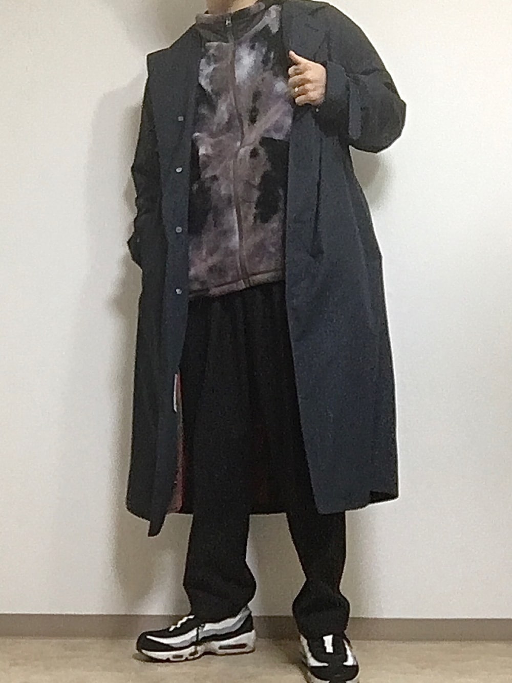 ブラック系のスラックス、ブラック系のチェスターコート、ブラック系のスニーカーを着用したメンズの冬コーディネートの1枚目の写真