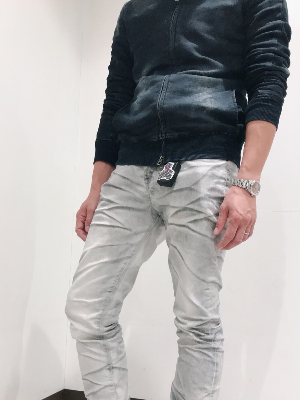 ホワイト系のデニムパンツ、ブルー系のジャージ、その他のスニーカーを着用したメンズの冬コーディネートの1枚目の写真