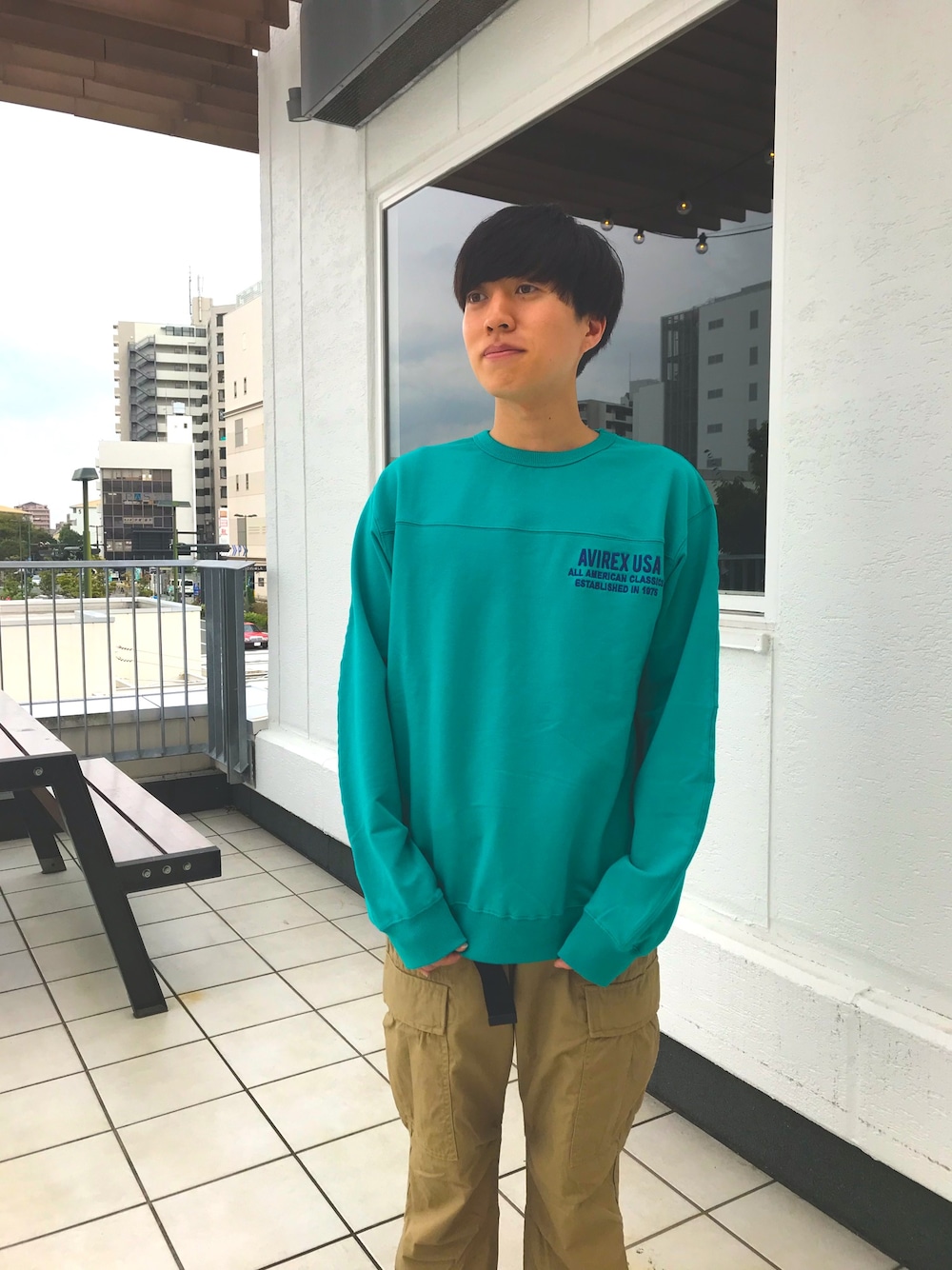 グリーン系のスウェット、グリーン系のカーゴパンツ、ブラック系のベルトを着用したメンズの秋コーディネートの1枚目の写真