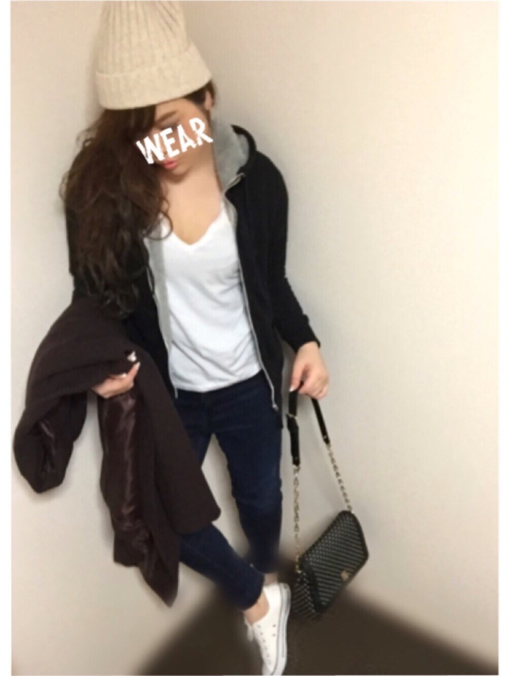 ブラウン系のチェスターコート、ブルー系のデニムパンツ、ホワイト系のスニーカーを着用したレディースの冬コーディネートの1枚目の写真