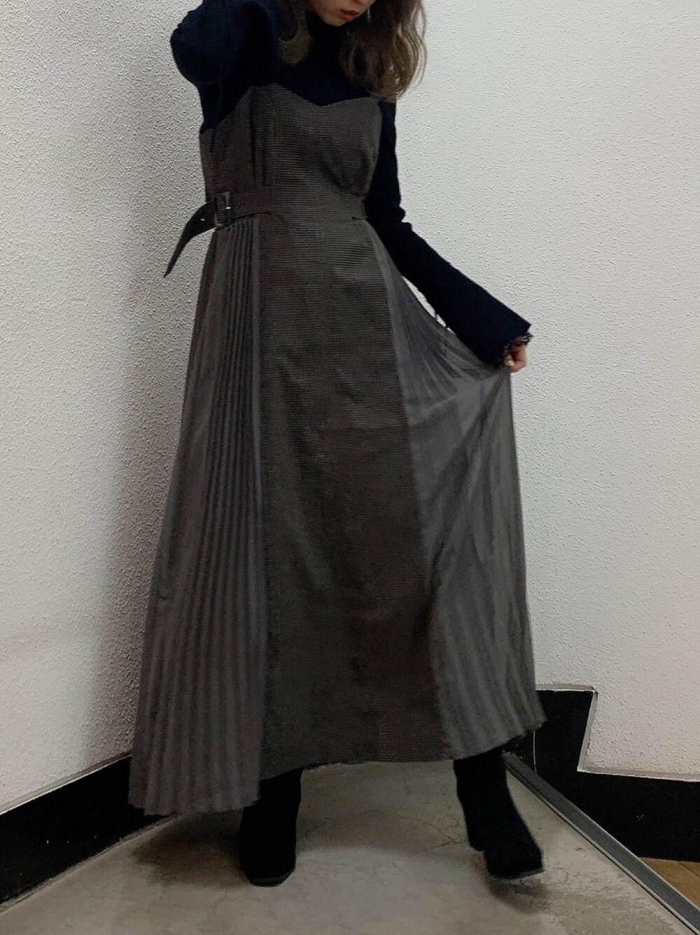 ブラック系のニット/セーター、グレー系のワンピース、ブラック系のブーツを着用したレディースの秋コーディネートの1枚目の写真