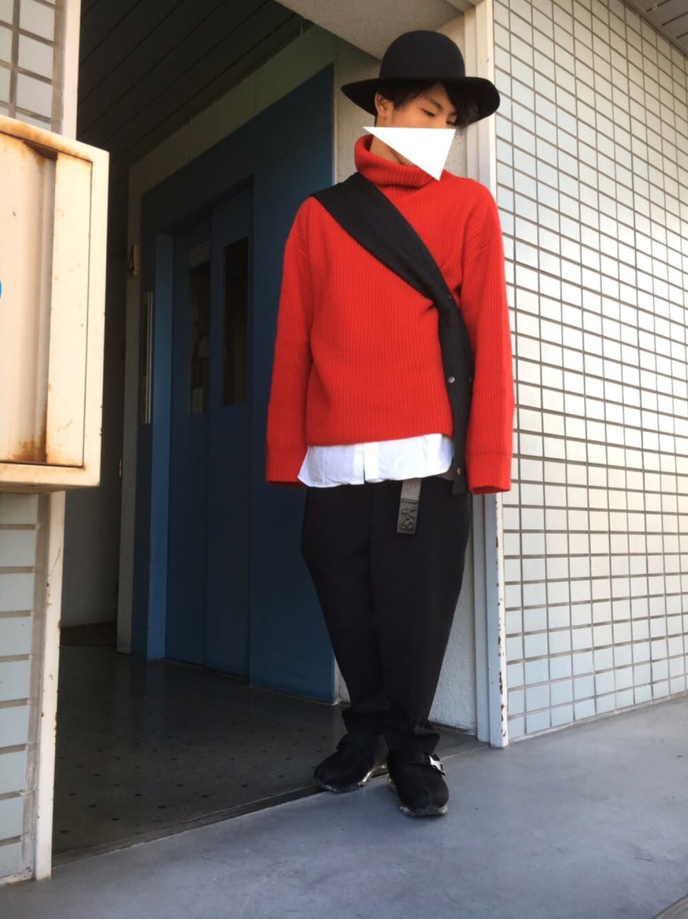 レッド系のニット/セーター、ブラック系のショルダーバッグ、ブラック系のスラックスを着用したメンズの秋コーディネートの1枚目の写真