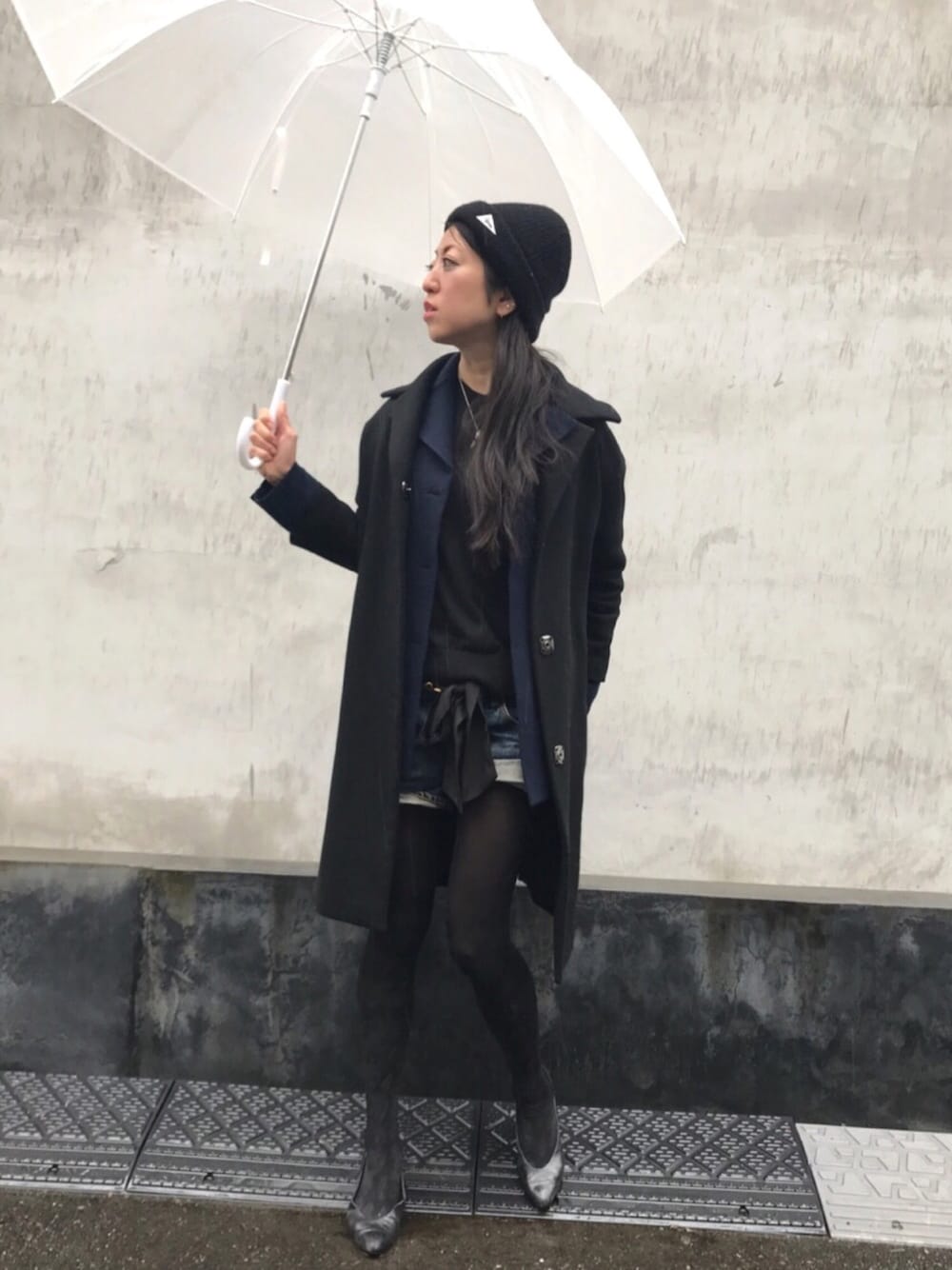 ブルー系のデニムパンツ、ブルー系のカーディガン/ボレロ、ブラック系のチェスターコートを着用したレディースの春コーディネートの1枚目の写真