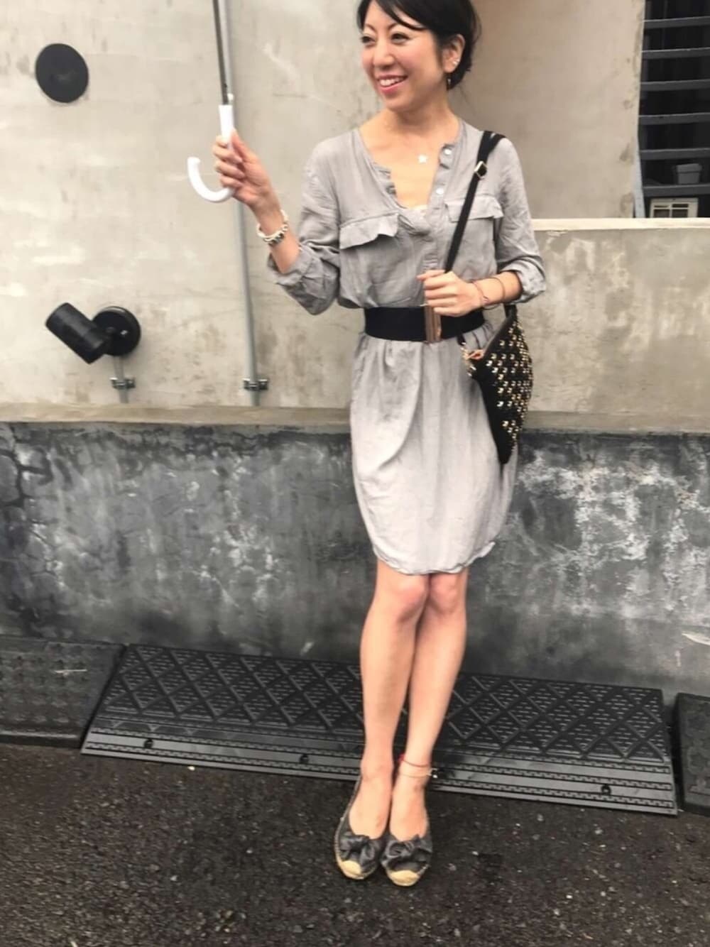 ブラック系のクラッチバッグ、ゴールド系のチャーム、ゴールド系のチャームを着用したレディースの夏コーディネートの1枚目の写真