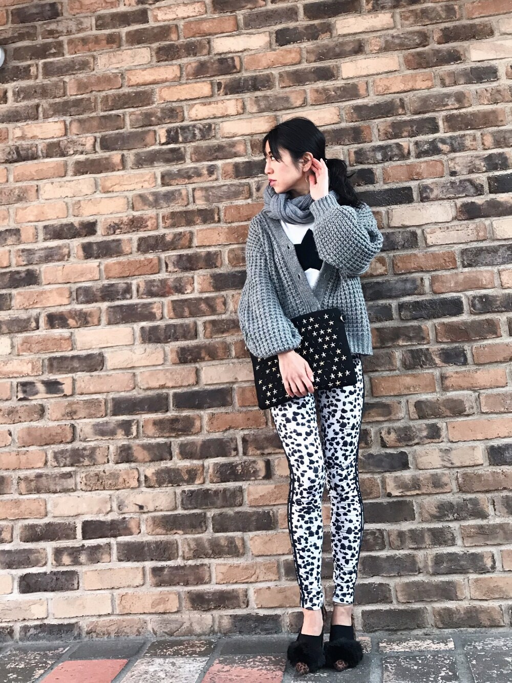 グレー系のニット/セーター、ブラック系のクラッチバッグ、その他のパンツを着用したレディースの冬コーディネートの1枚目の写真