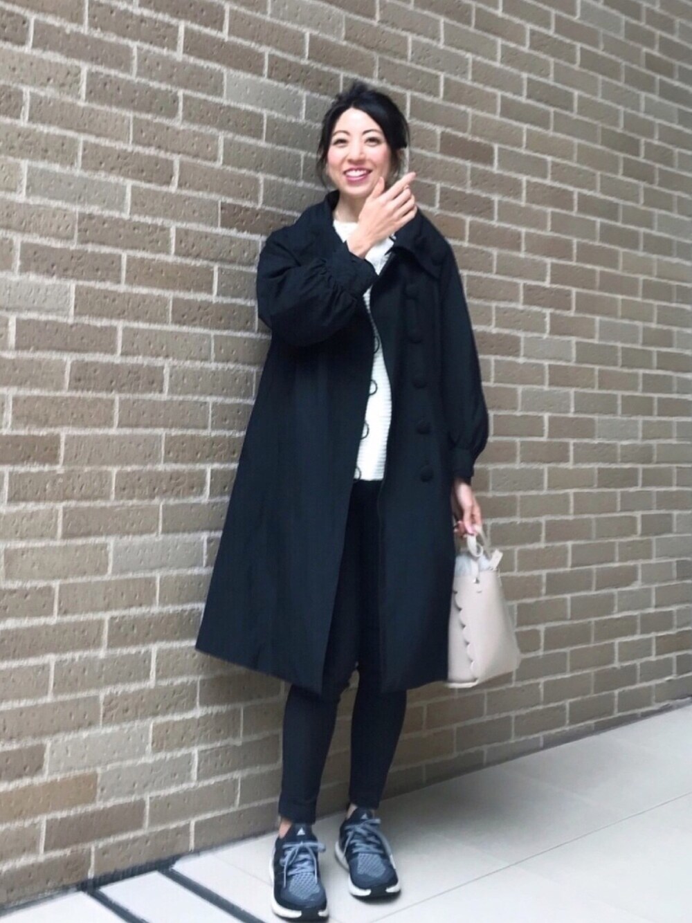 ホワイト系のニット/セーター、グレー系のスニーカー、ベージュ系のショルダーバッグを着用したレディースの秋コーディネートの1枚目の写真