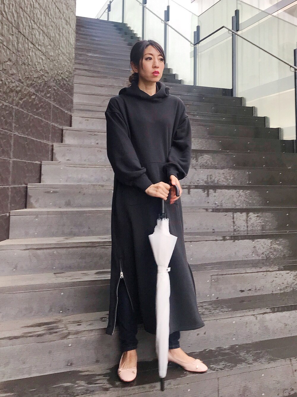 ブラック系のワンピース、ベージュ系のパンプス、ゴールド系のピアス(両耳用)を着用したレディースの夏コーディネートの1枚目の写真