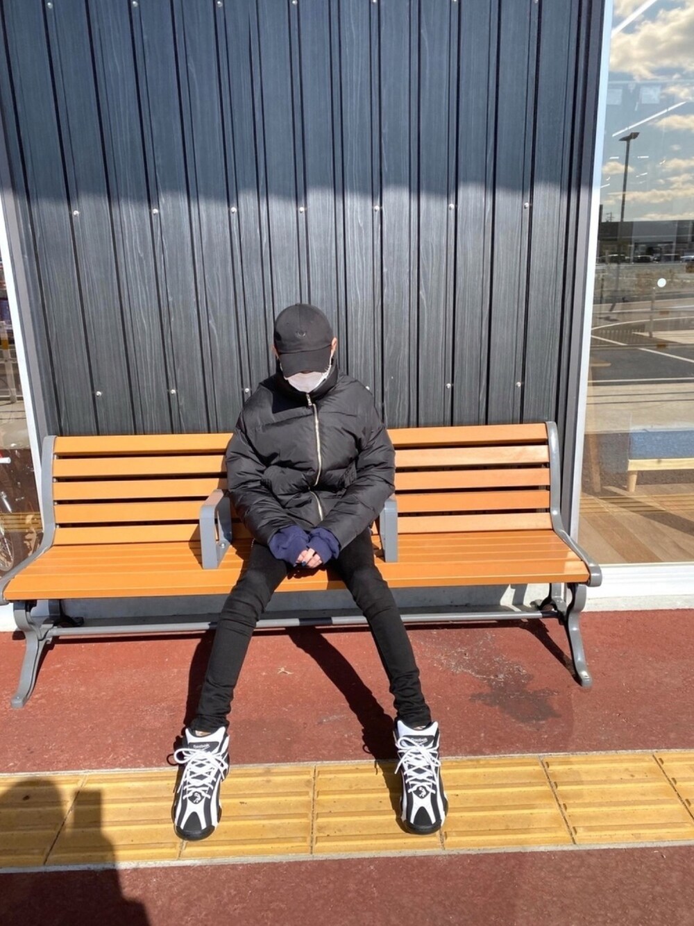 ブラック系のスニーカー、ブラック系のダウンジャケット/コート、ブラック系のデニムパンツを着用したメンズの冬コーディネートの1枚目の写真