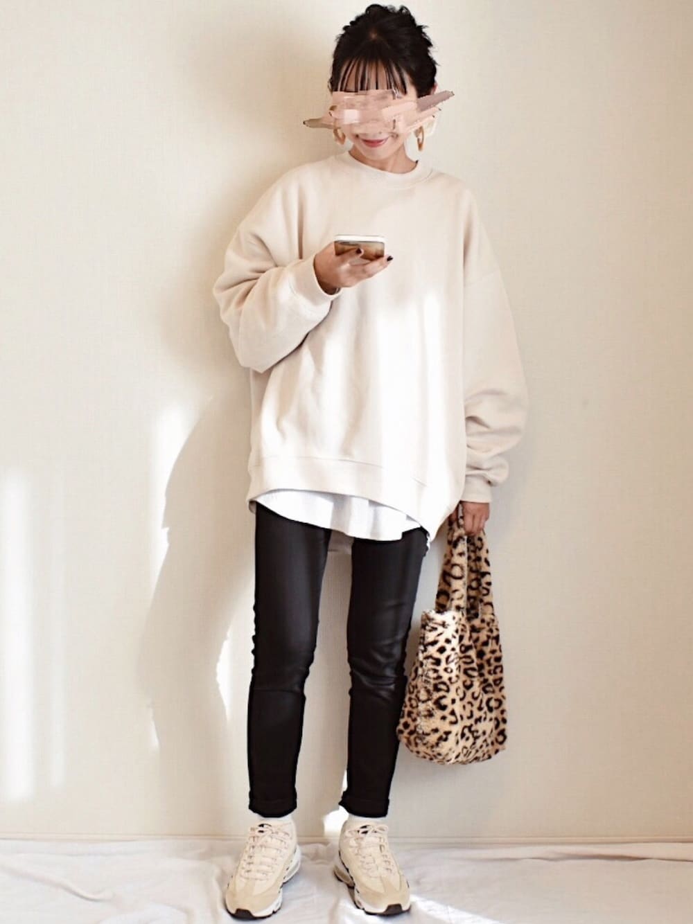 ベージュ系のスウェット、ホワイト系のTシャツ/カットソー、ブラック系のデニムパンツを着用したレディースの冬コーディネートの1枚目の写真