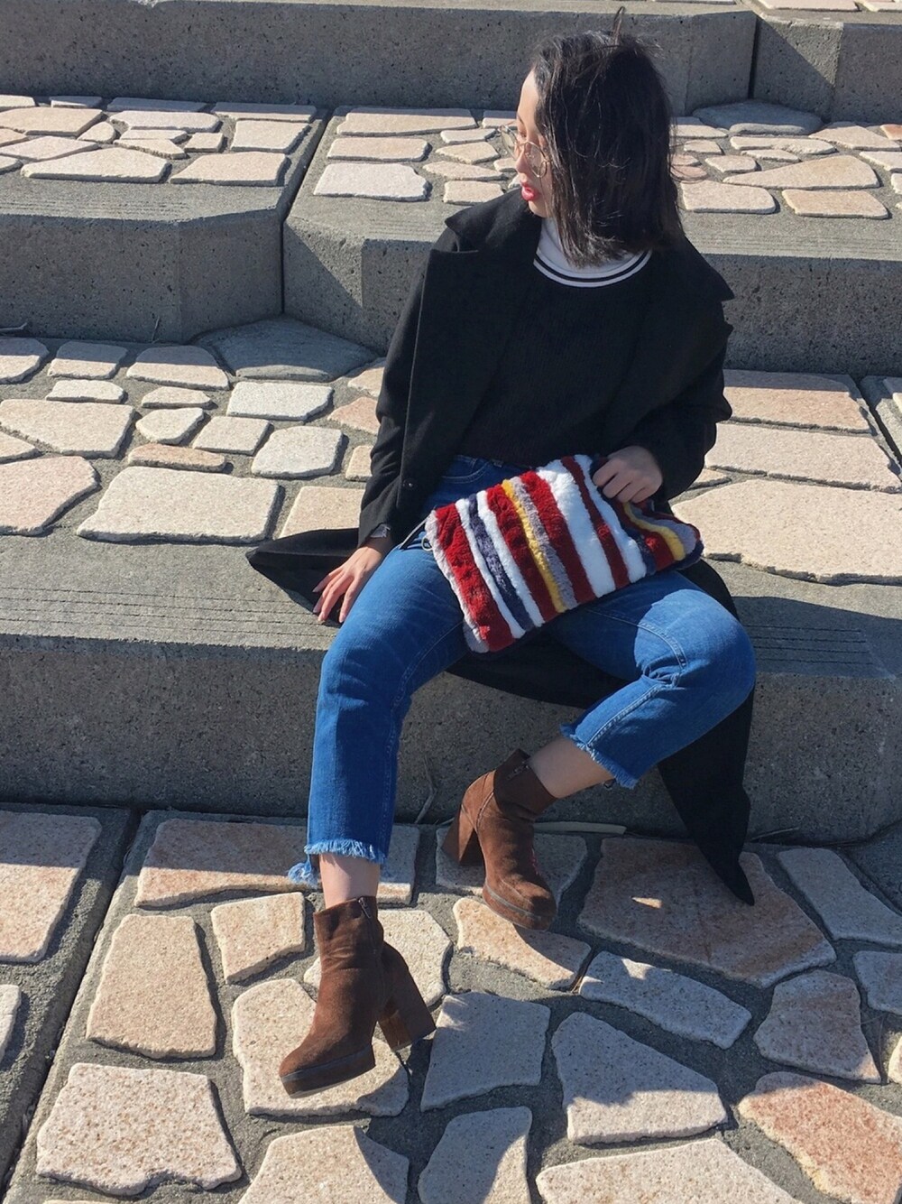 その他のクラッチバッグ、ブルー系のデニムパンツ、ブラウン系のブーツを着用したレディースの冬コーディネートの1枚目の写真