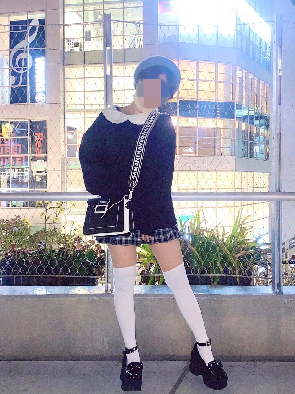 ブラック系のトップス、ブラック系のスカート、ブラック系のハンドバッグを着用したレディースの春コーディネートの1枚目の写真