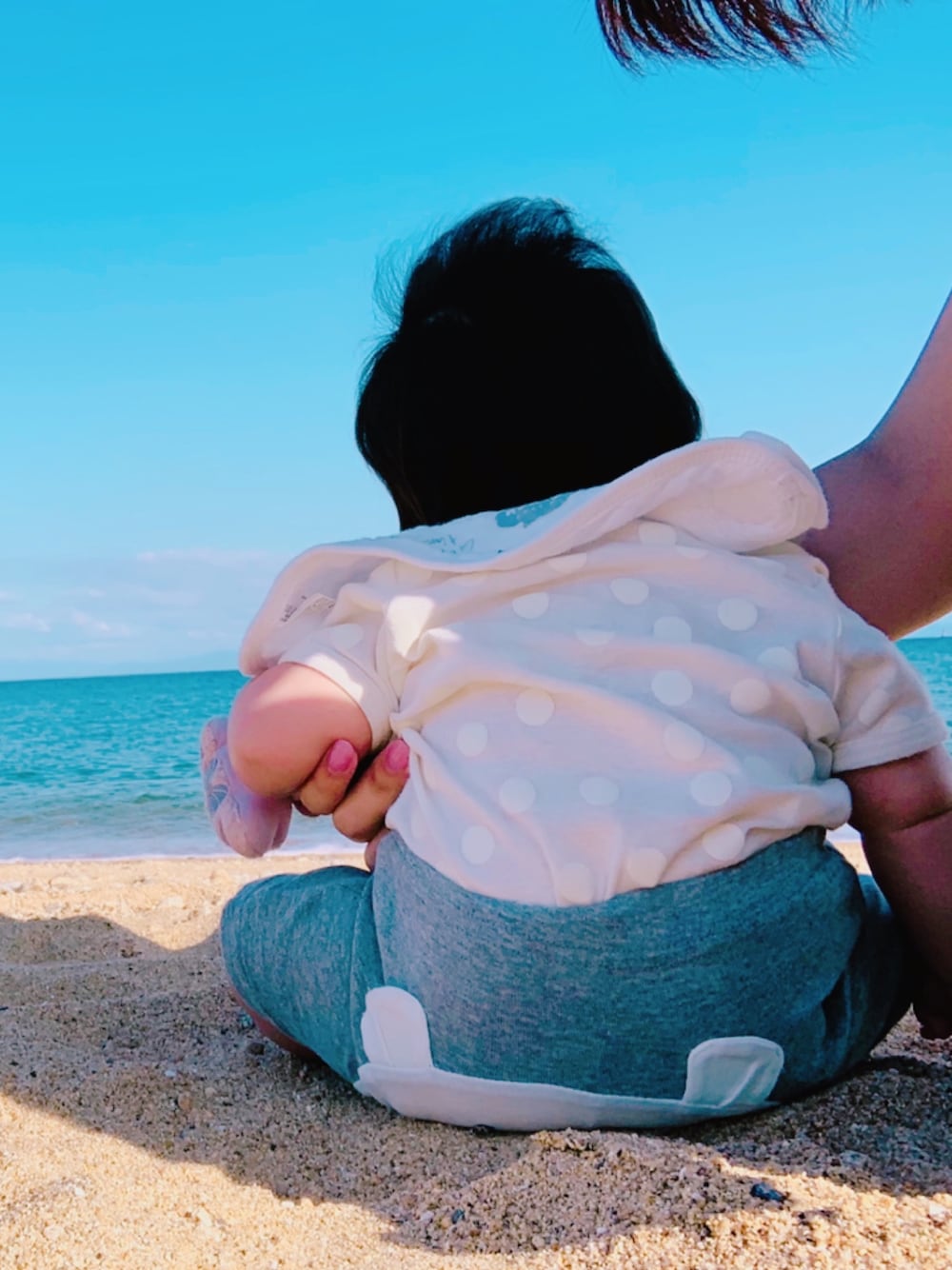 ホワイト系のスタイ/よだれかけ、ホワイト系のロンパース、グレー系のその他ベビー用品を着用したキッズの秋コーディネートの1枚目の写真