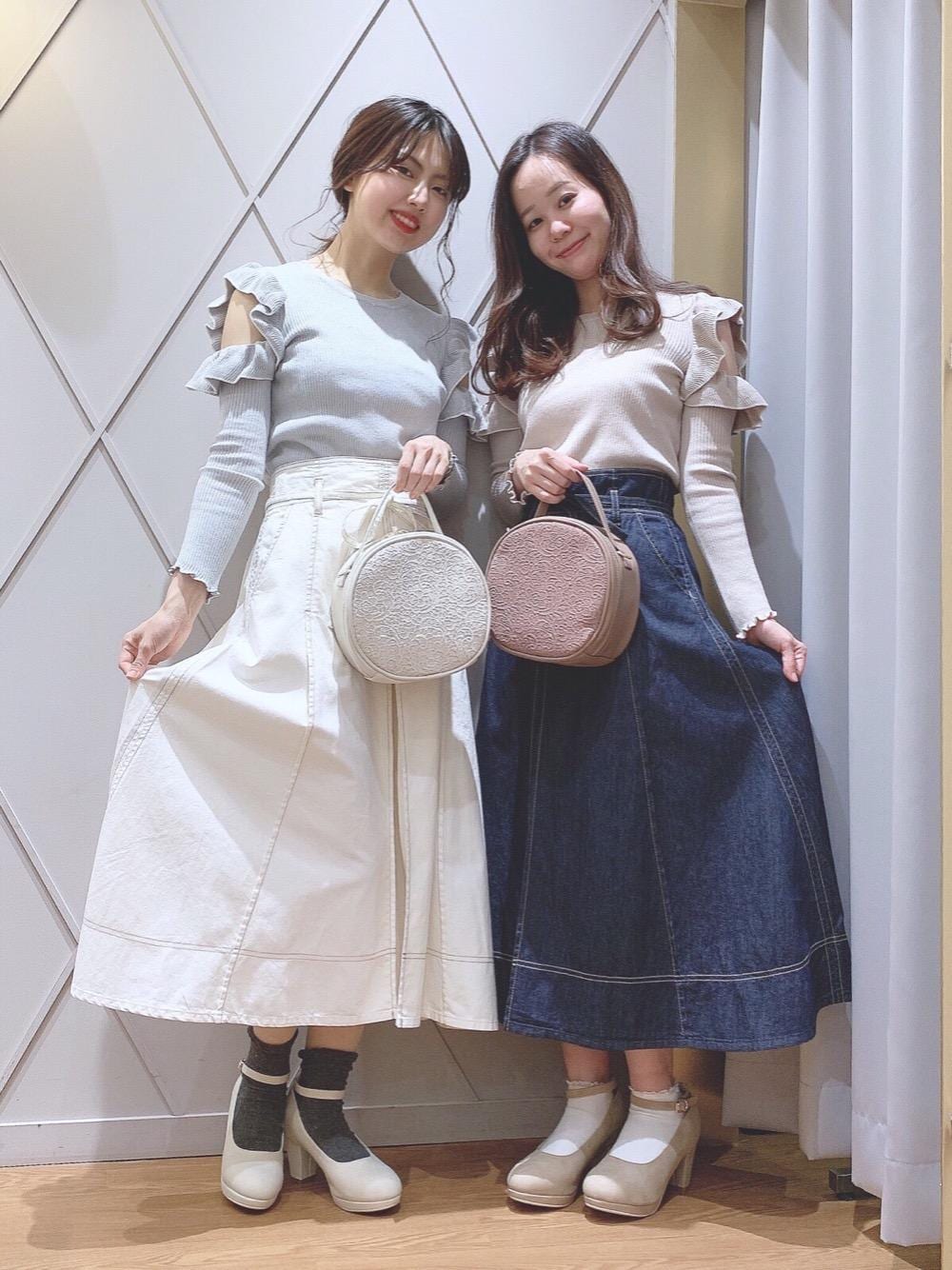 ベージュ系のパンプス、ホワイト系のパンプス、ホワイト系のハンドバッグを着用したレディースの冬コーディネートの1枚目の写真