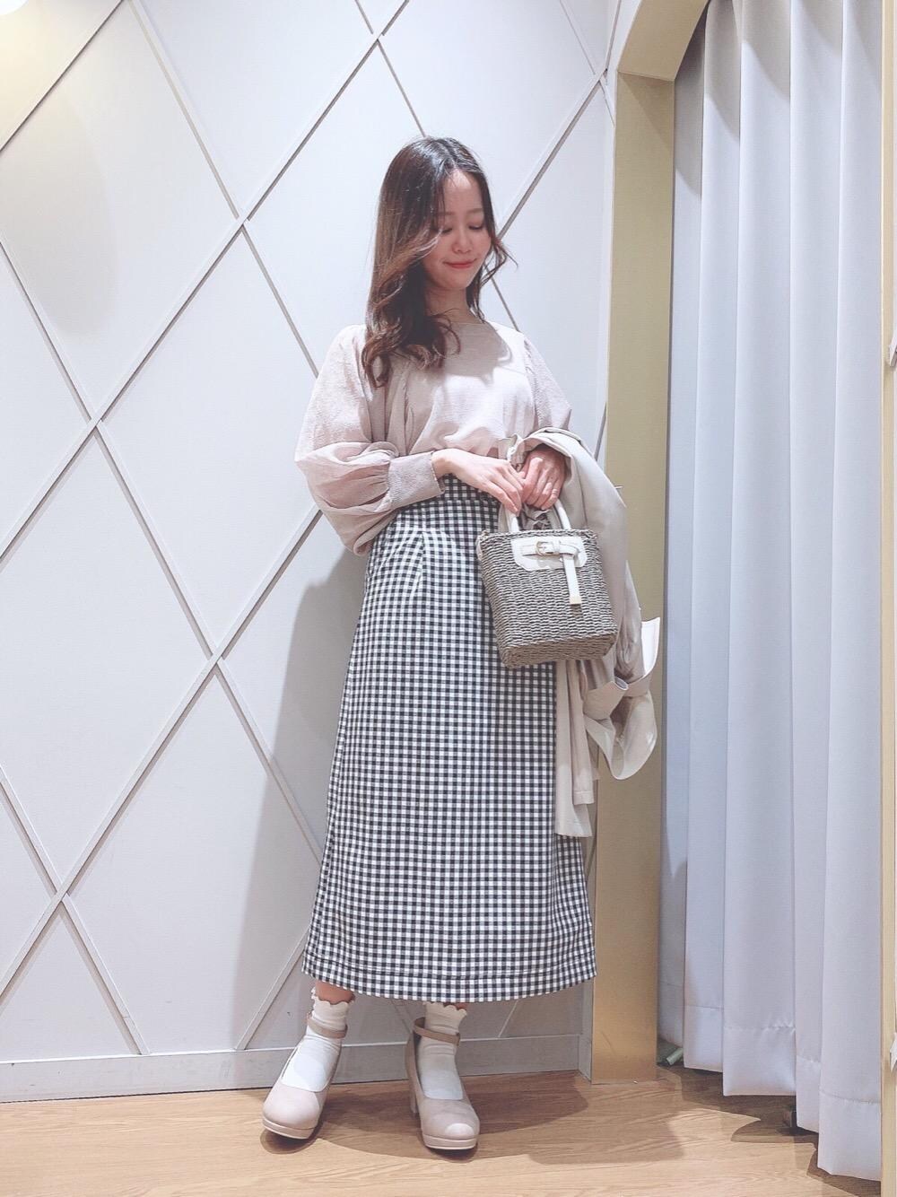 ピンク系のパンプス、ベージュ系のニット/セーター、ベージュ系のかごバッグを着用したレディースの冬コーディネートの1枚目の写真