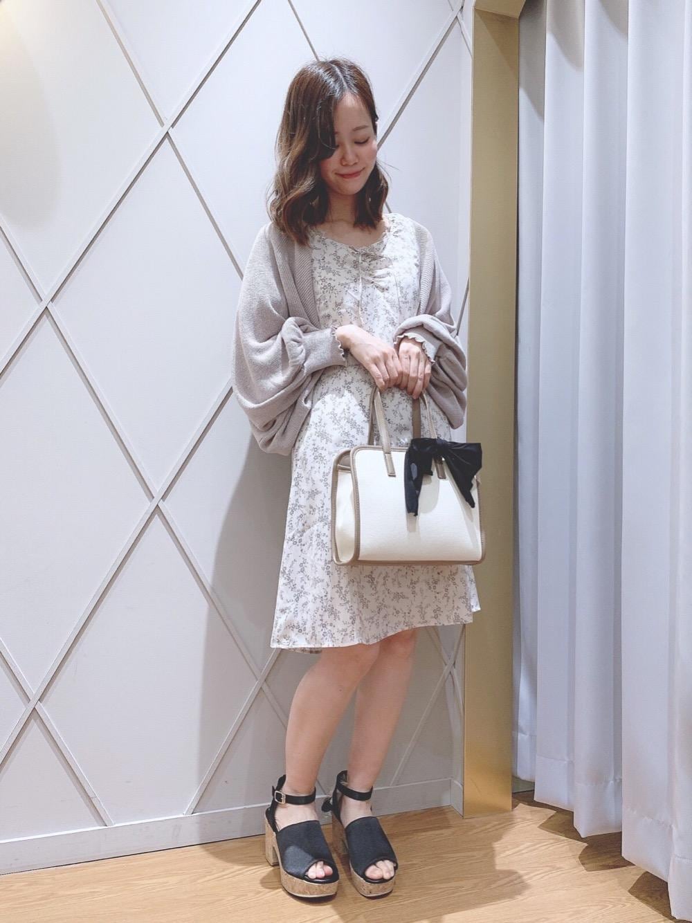 ブラック系のサンダル、ブラウン系のハンドバッグ、ベージュ系のタンクトップを着用したレディースの春コーディネートの1枚目の写真