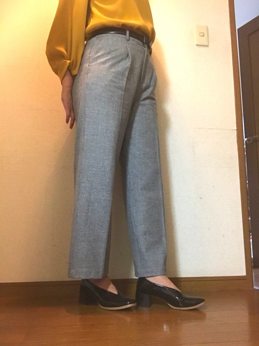 グレー系のその他パンツ、イエロー系のシャツ/ブラウス、ブラック系のパンプスを着用したレディースの秋コーディネートの1枚目の写真