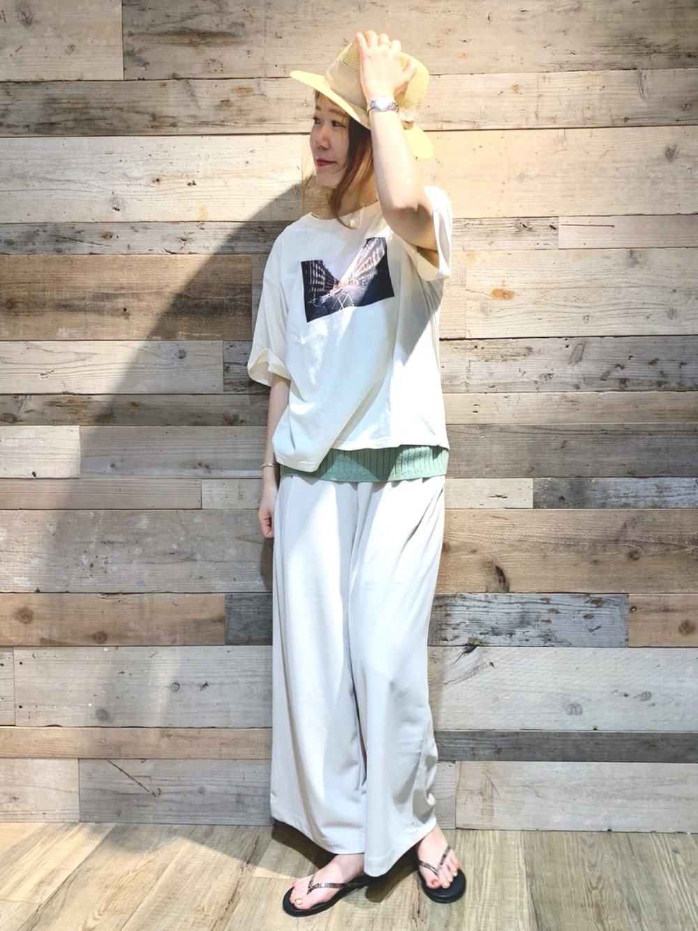 ホワイト系のスラックス、グリーン系のベスト、ホワイト系のTシャツ/カットソーを着用したレディースの春コーディネートの1枚目の写真