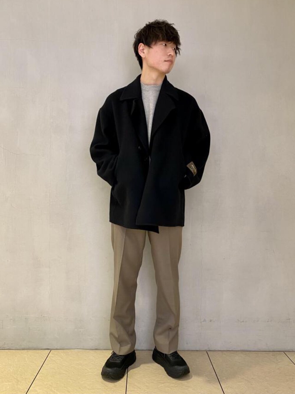 ブラック系のその他アウター、グレー系のスラックス、ブラック系のシューズを着用したメンズの冬コーディネートの1枚目の写真