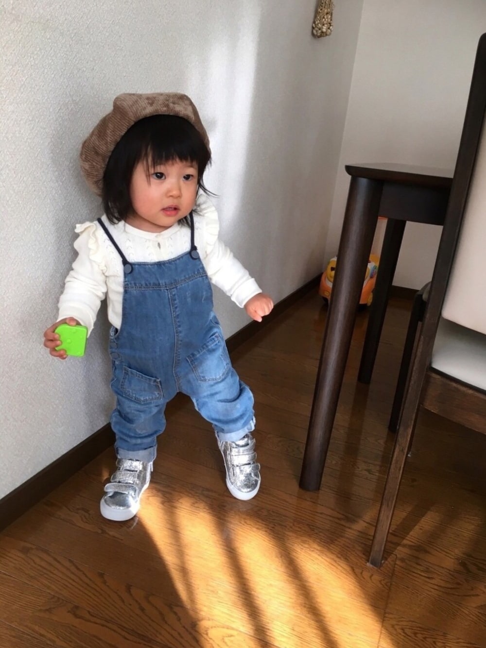 ホワイト系のカーディガン/ボレロ、ブルー系のサロペット/オーバーオール、シルバー系のスニーカーを着用したキッズの秋コーディネートの1枚目の写真