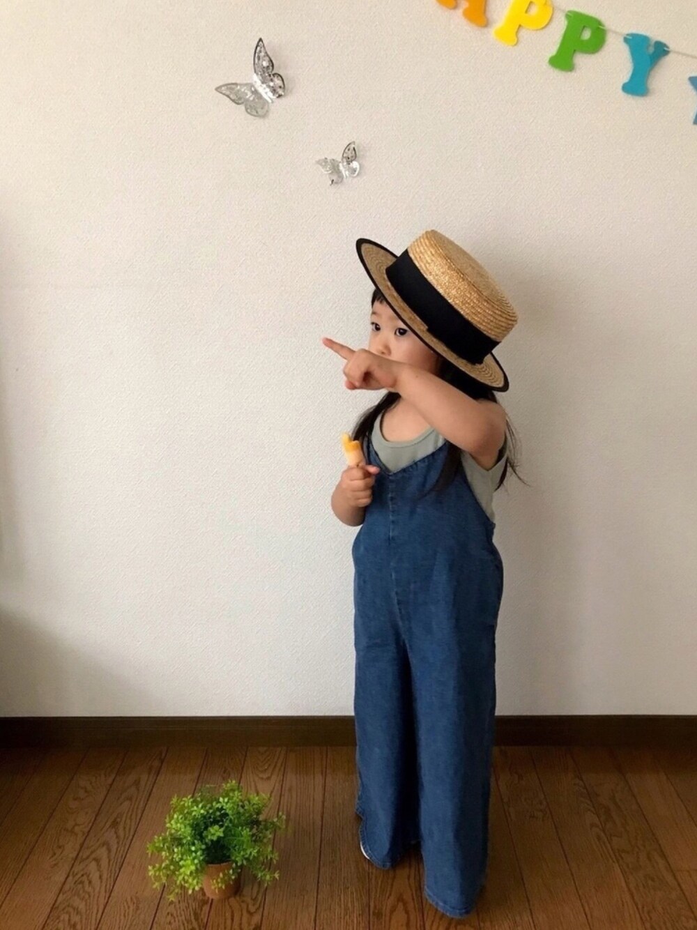 グリーン系のタンクトップ、ブルー系のオールインワン・サロペット、ベージュ系のモカシン/デッキシューズを着用したキッズの夏コーディネートの1枚目の写真