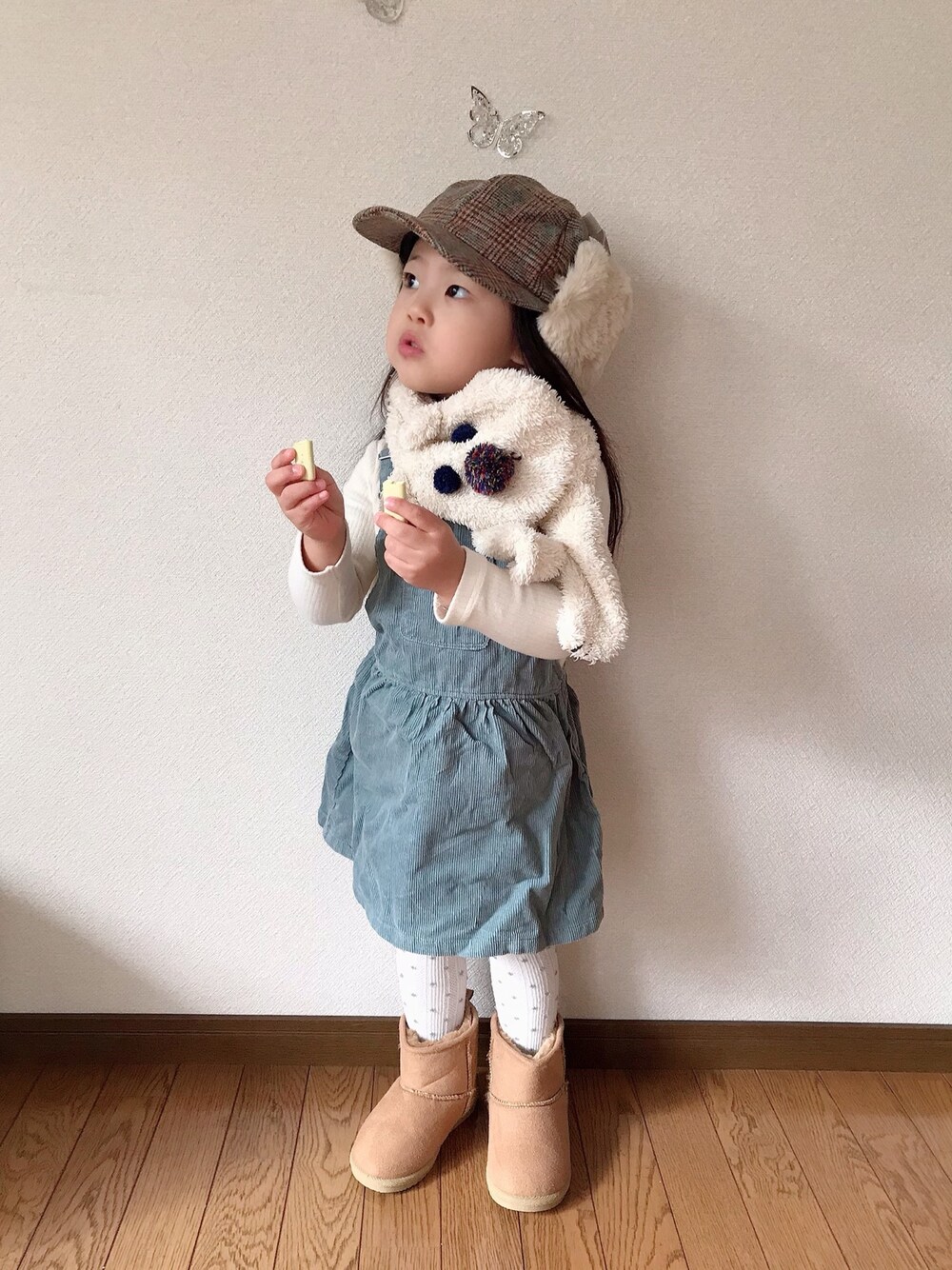 ホワイト系のその他トップス、グリーン系のジャンパースカート、ベージュ系のブーツを着用したキッズの秋コーディネートの1枚目の写真