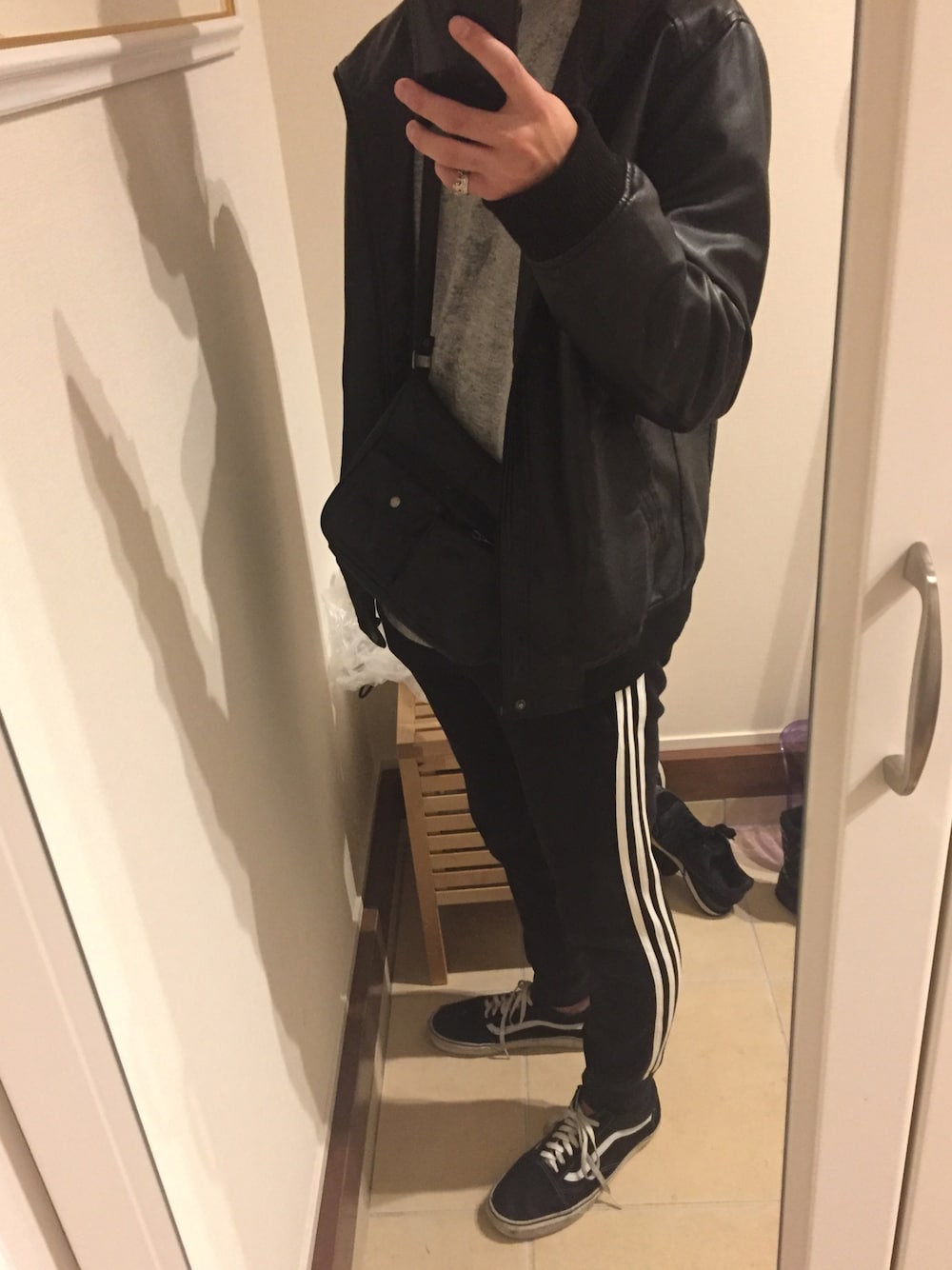 ブラック系のライダースジャケット、ブラック系のパンツ、ブラック系のスニーカーを着用したメンズの冬コーディネートの1枚目の写真