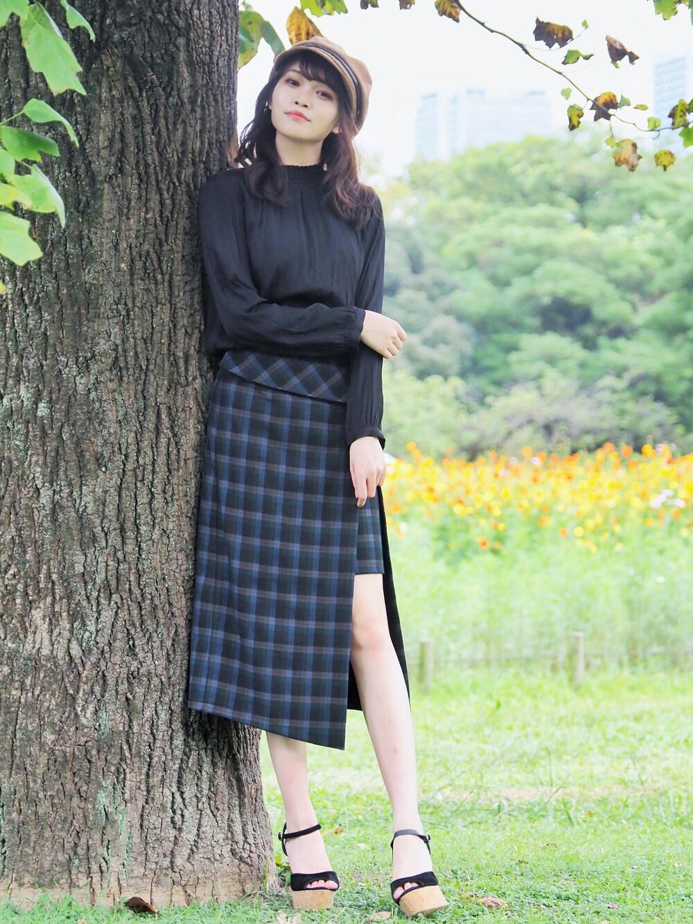 ブラック系のシャツ/ブラウス、グリーン系のスカート、ブラック系のサンダルを着用したレディースの秋コーディネートの1枚目の写真