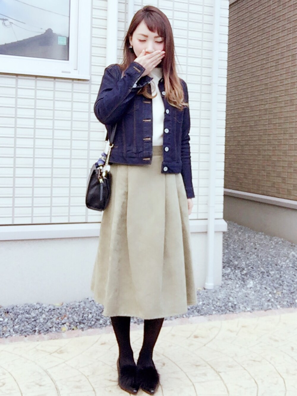 ブルー系のデニムジャケット、ホワイト系のニット/セーター、グリーン系のスカートを着用したレディースの冬コーディネートの1枚目の写真