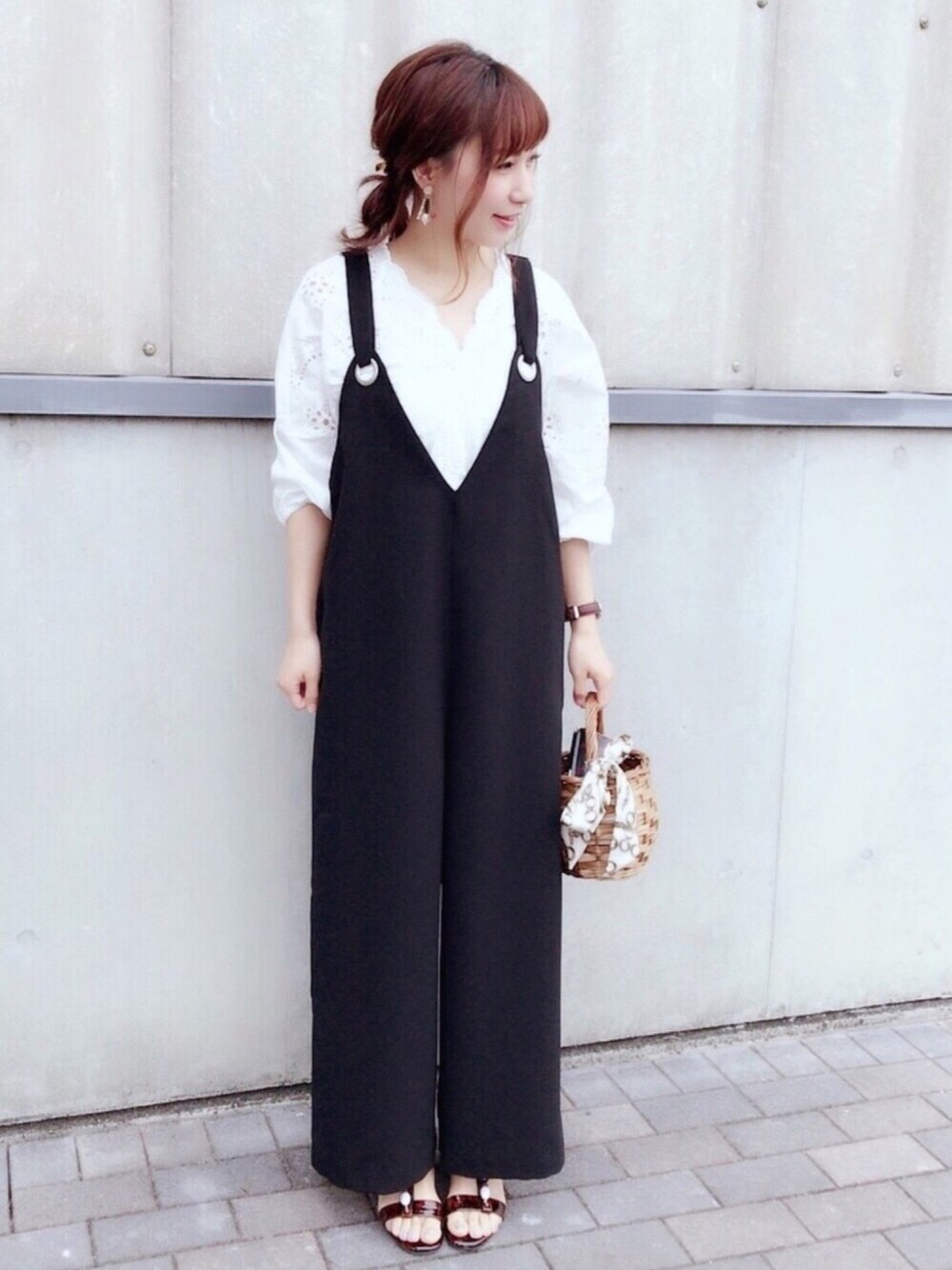 ホワイト系のシャツ/ブラウス、ブラック系のサロペット/オーバーオール、ベージュ系のかごバッグを着用したレディースの夏コーディネートの1枚目の写真