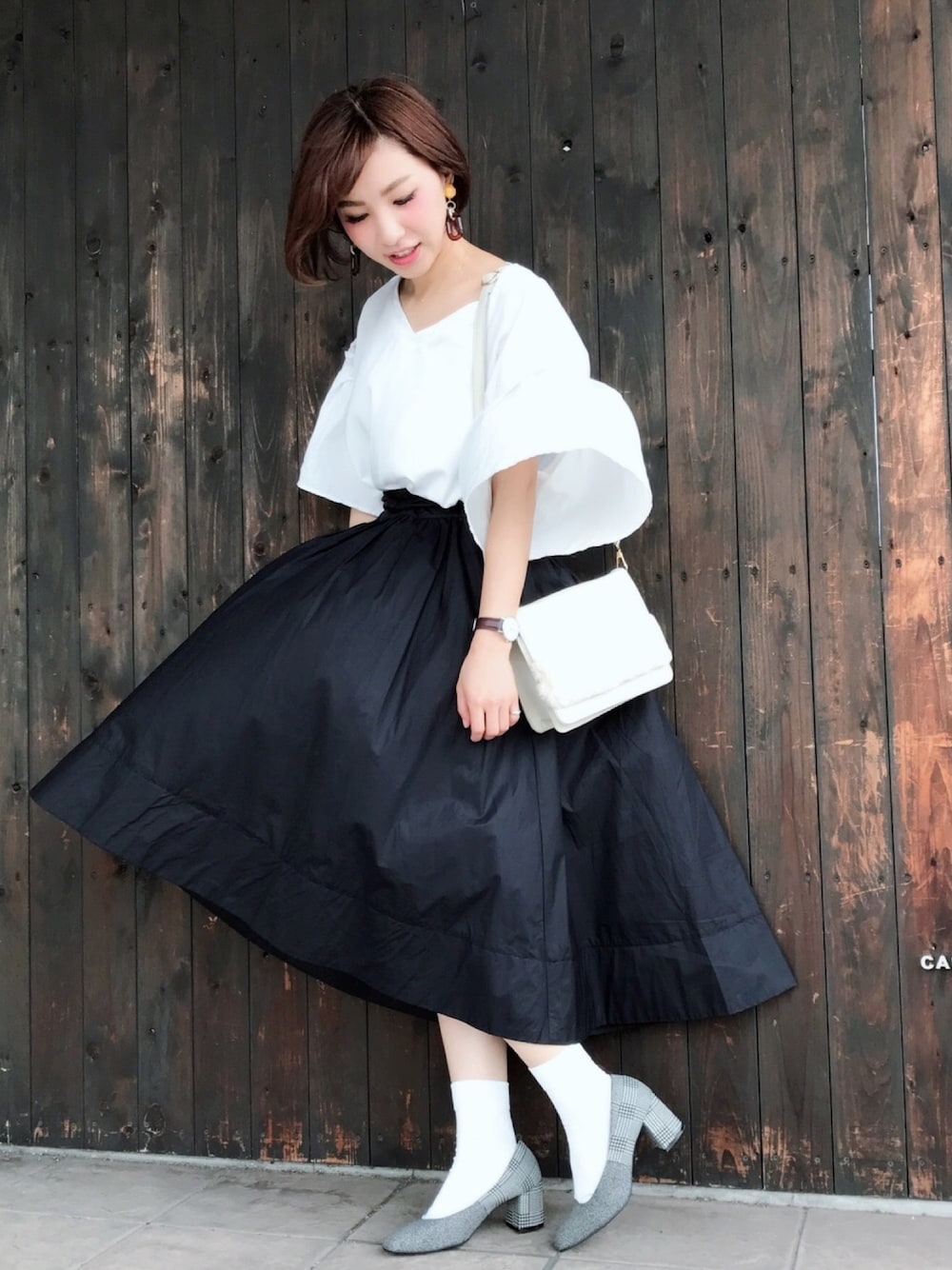 ホワイト系のシャツ/ブラウス、ブラック系のスカート、ブラック系のパンプスを着用したレディースの秋コーディネートの1枚目の写真