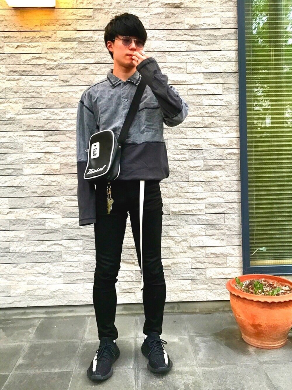グレー系のTシャツ/カットソー、ブラック系のショルダーバッグ、ブラック系のデニムパンツを着用したメンズの夏コーディネートの1枚目の写真