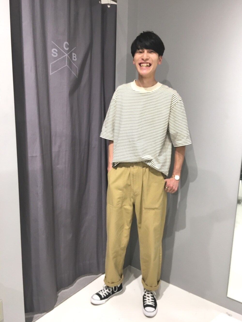 ホワイト系のTシャツ/カットソー、ベージュ系のチノパンツ、ブラック系のスニーカーを着用したメンズの春コーディネートの1枚目の写真