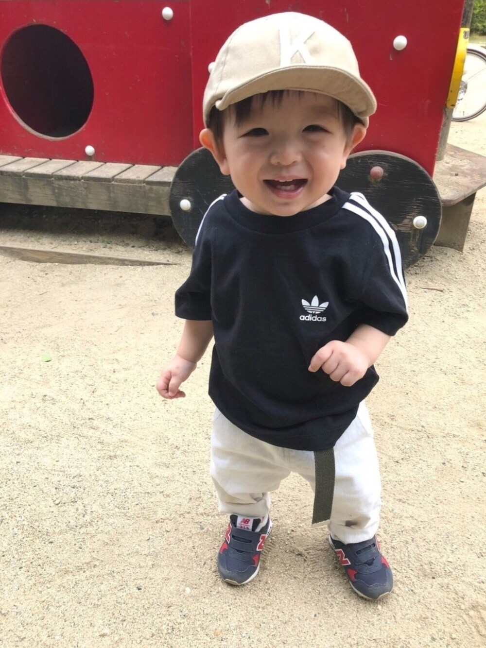ブラック系のTシャツ/カットソー、ブルー系のスニーカー、ベージュ系のキャップを着用したキッズの夏コーディネートの1枚目の写真