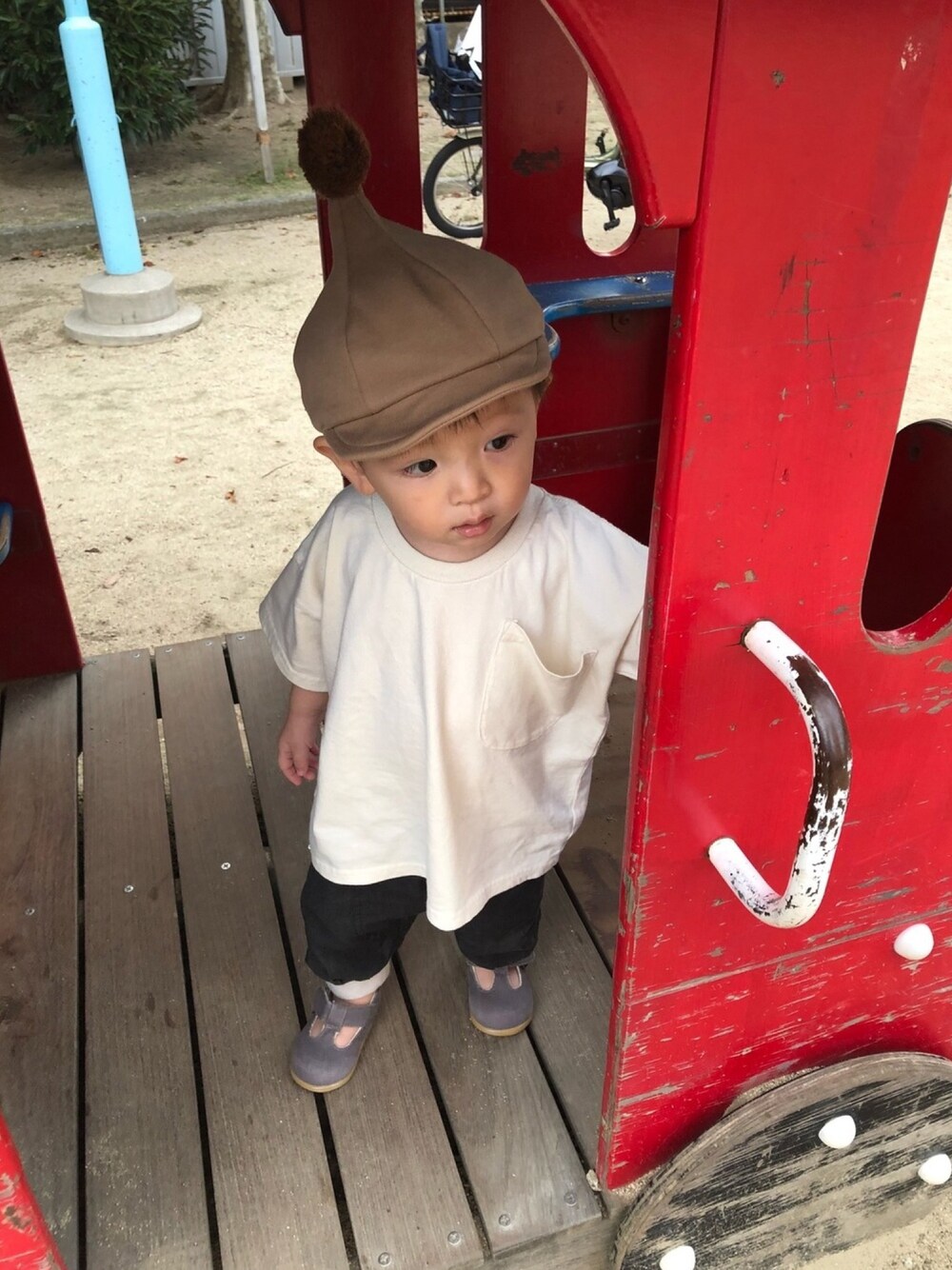 ベージュ系のTシャツ/カットソー、ブラック系のその他パンツ、ベージュ系のキャップを着用したキッズの秋コーディネートの1枚目の写真