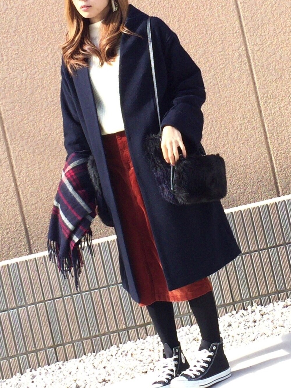 ホワイト系のニット/セーター、レッド系のスカート、ブルー系のノーカラージャケットを着用したレディースの冬コーディネートの1枚目の写真