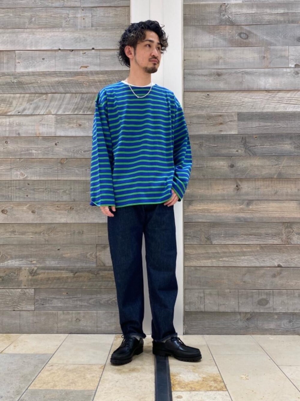 ブルー系のTシャツ/カットソー、ブラック系のドレスシューズ、ブルー系のデニムパンツを着用したメンズの秋コーディネートの1枚目の写真