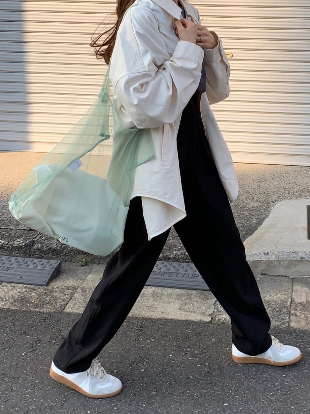 ホワイト系のスニーカーを着用したレディースの春コーディネートの1枚目の写真