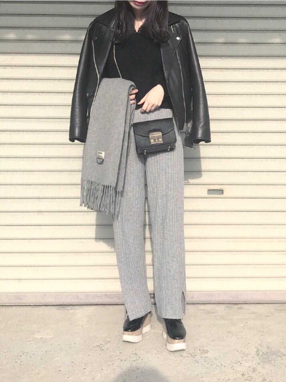 ブラック系のニット/セーター、ブラック系のショルダーバッグ、グレー系のその他パンツを着用したレディースの冬コーディネートの1枚目の写真