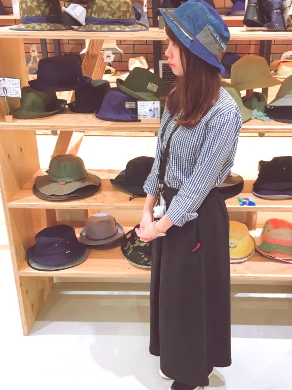 ブルー系のハットを着用したレディースの夏コーディネートの1枚目の写真