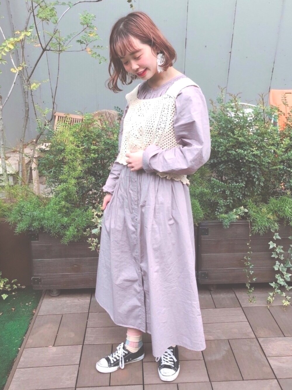 パープル系のワンピース、ホワイト系のニット/セーターを着用したレディースの春コーディネートの1枚目の写真