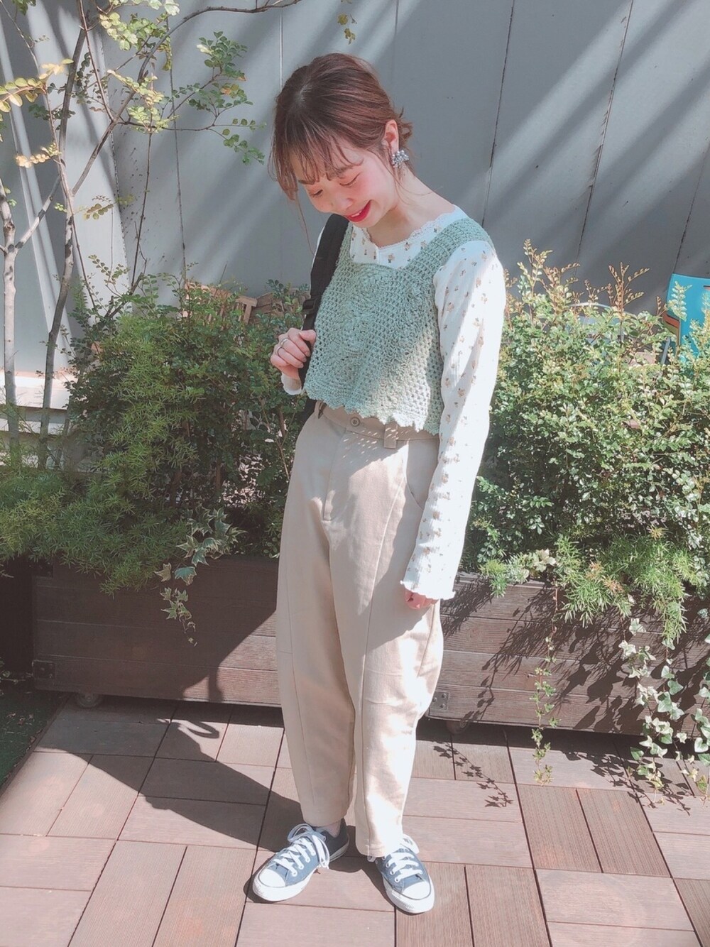 グリーン系のニット/セーター、ベージュ系のその他パンツ、ブルー系のスニーカーを着用したレディースの春コーディネートの1枚目の写真