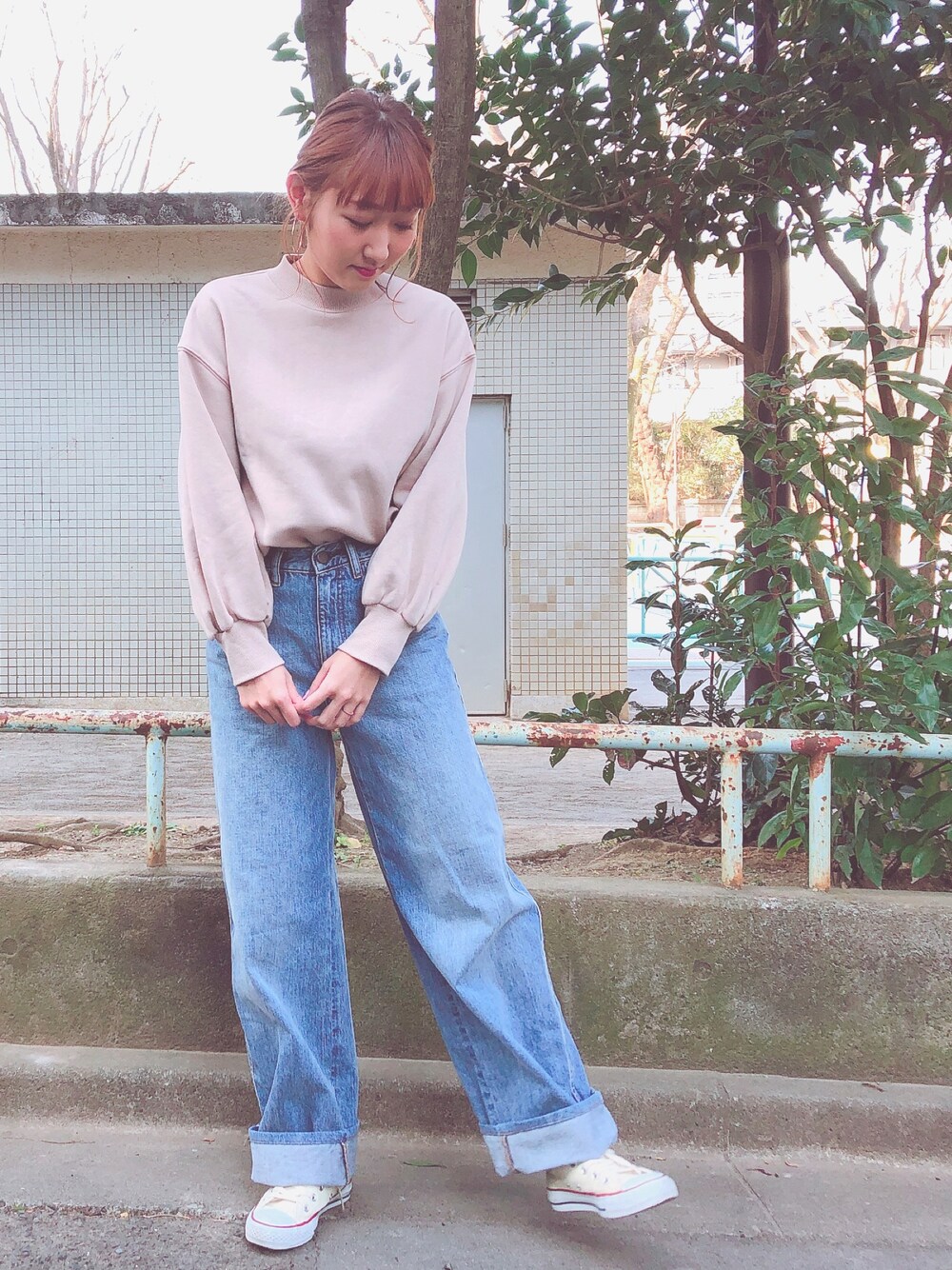 ホワイト系のスニーカー、ブルー系のデニムパンツ、ベージュ系のスウェットを着用したレディースの冬コーディネートの1枚目の写真