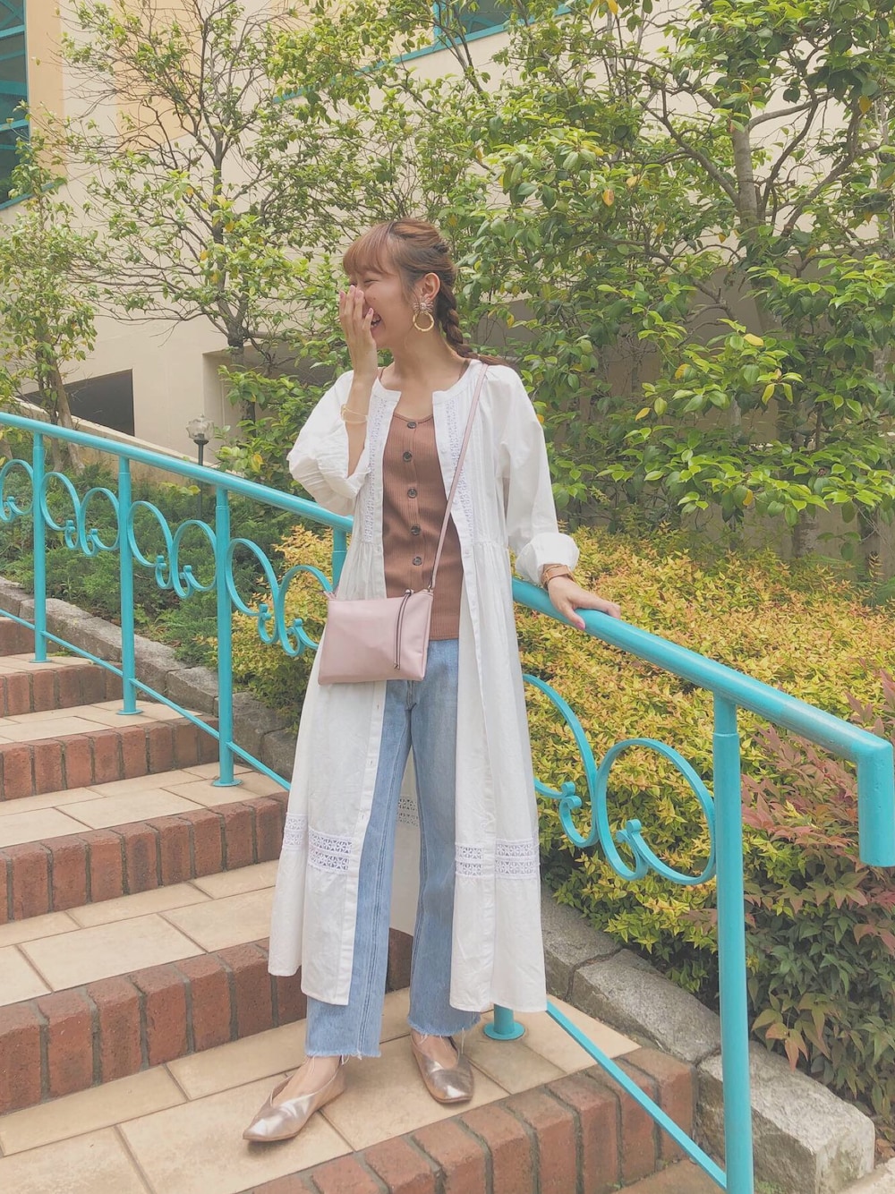 ゴールド系のスリッポン、ブルー系のデニムパンツ、ホワイト系のワンピースを着用したレディースの夏コーディネートの1枚目の写真