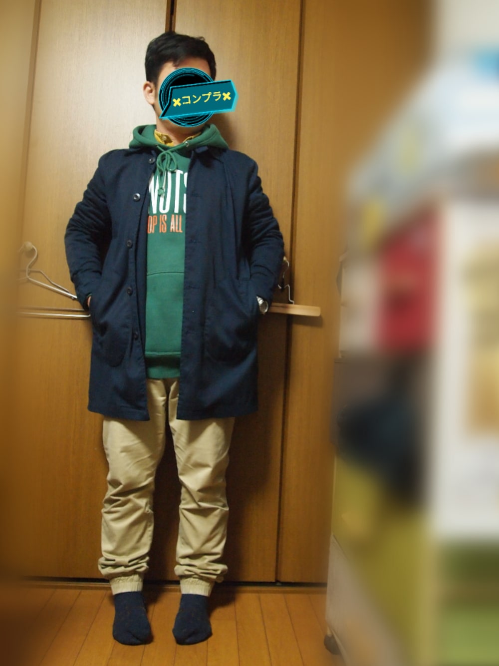 イエロー系のシャツ/ブラウス、ブルー系のステンカラーコート、グリーン系のパーカーを着用したメンズの秋コーディネートの1枚目の写真