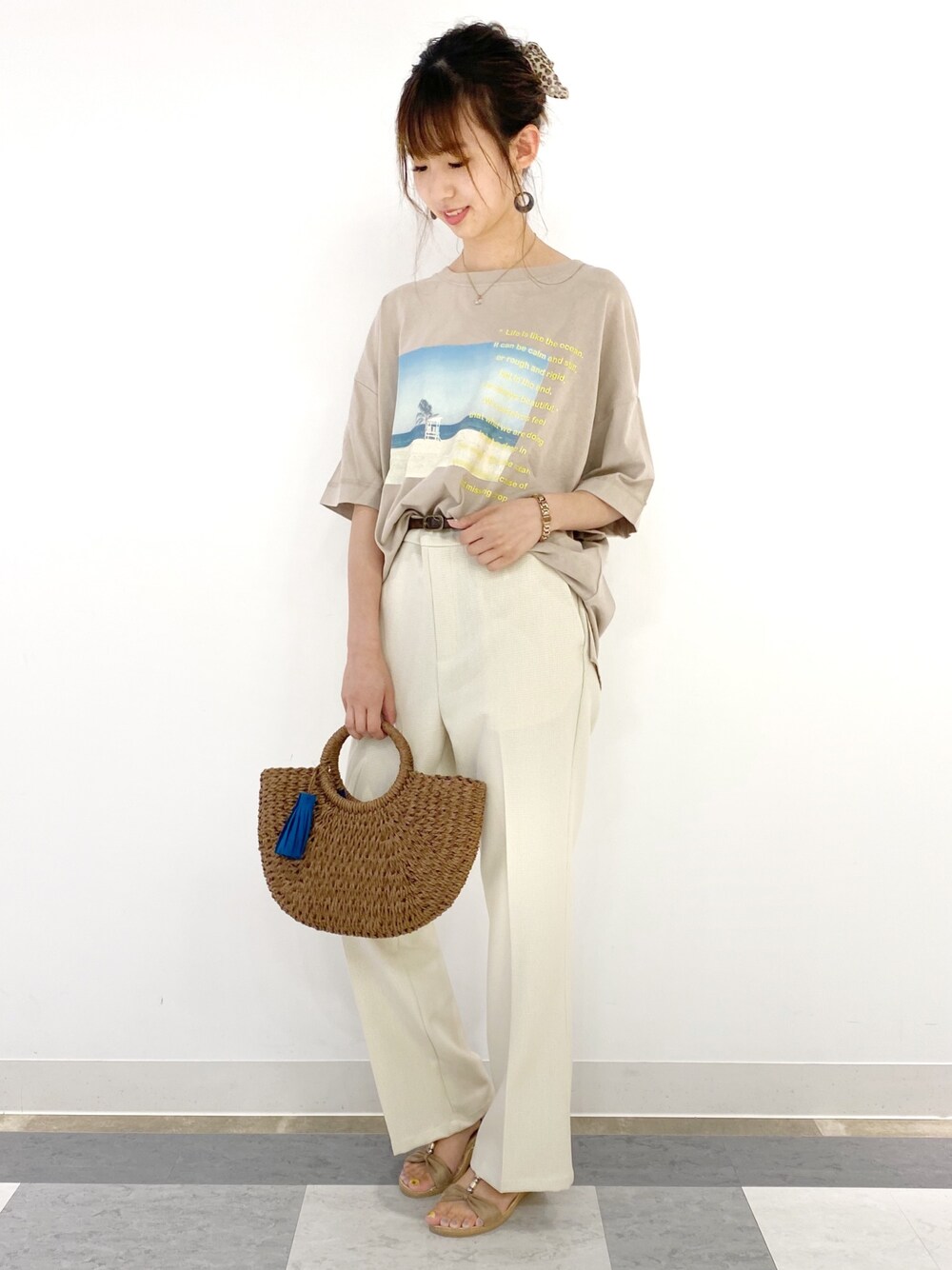 ベージュ系のTシャツ/カットソー、ホワイト系のパンツ、ブラウン系のかごバッグを着用したレディースの夏コーディネートの1枚目の写真
