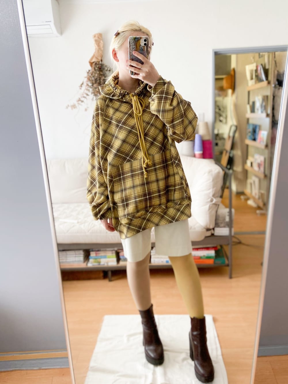 イエロー系のパーカー、ホワイト系のその他パンツ、ブラウン系のブーツを着用したレディースの秋コーディネートの1枚目の写真