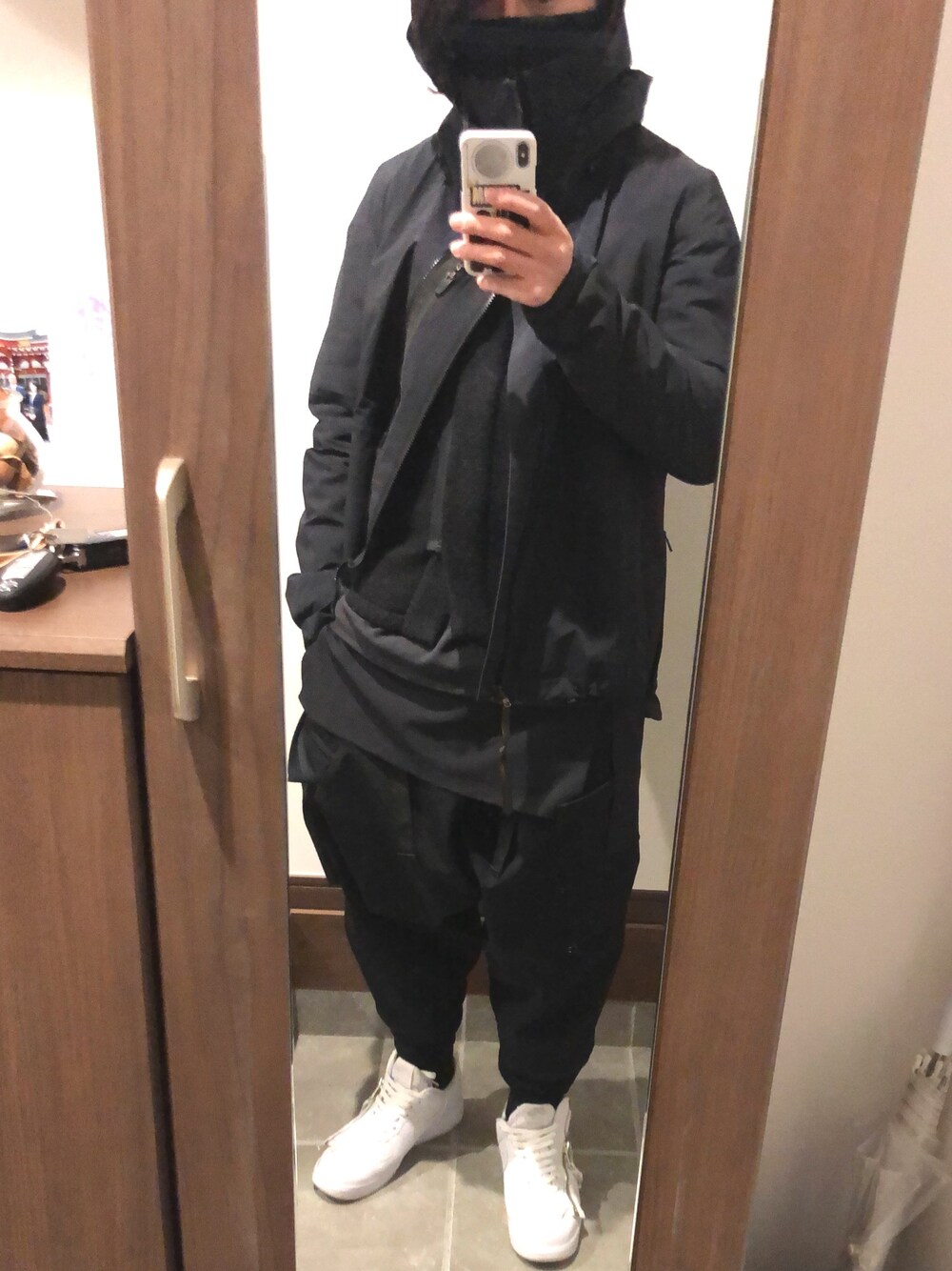 ブラック系のナイロンジャケット、ブラック系のニット/セーター、ブラック系のTシャツ/カットソーを着用したメンズの冬コーディネートの1枚目の写真